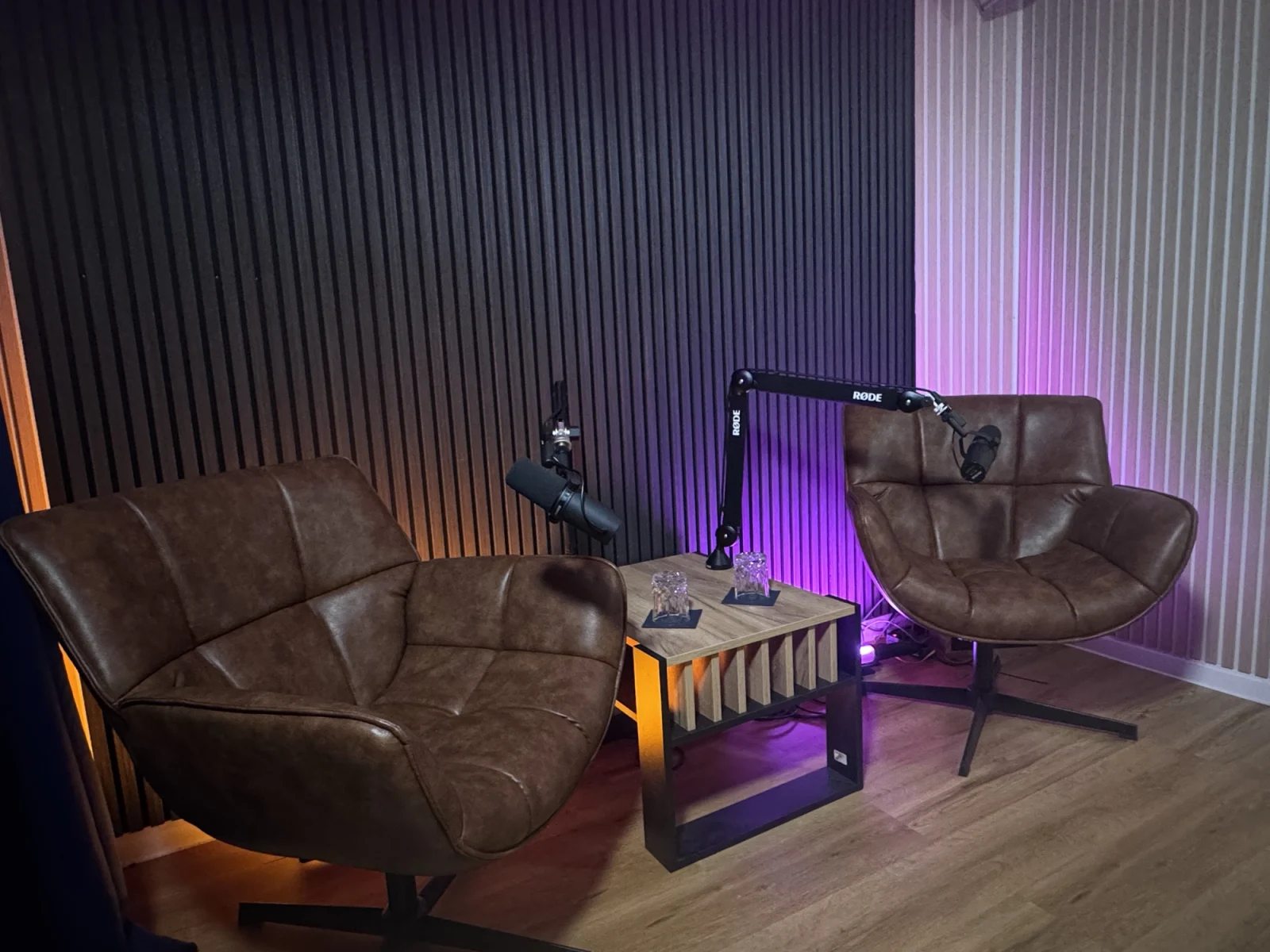 The Booth (Set 3) in the control room: two lounge chairs with podcast microphones